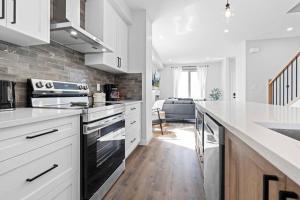 a kitchen with white cabinets and a counter top at Modern Luxury Home - King Bed•Arcade•WEM•A/C in Edmonton