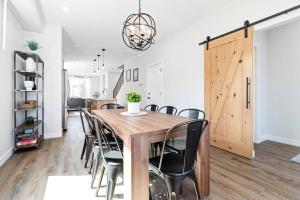 a dining room with a wooden table and chairs at Modern Luxury Home - King Bed•Arcade•WEM•A/C in Edmonton