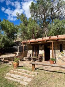 um edifício com um alpendre com cadeiras e árvores em Cabañas Malka em Tilcara