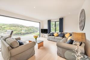 a living room with two couches and a large window at Beach View in Ilfracombe