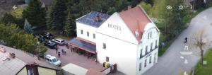 an overhead view of a white building with cars parked outside at Bike Hostel&Camp in Przewóz