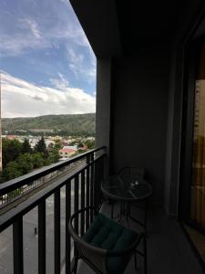 einen Balkon mit einem Tisch und Stühlen sowie Aussicht in der Unterkunft Gvazi Apartment in Tbilisi City