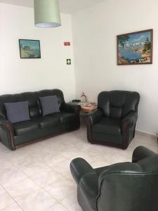 salon z dwoma czarnymi kanapami i stołem w obiekcie Casa Elias w mieście Nordeste