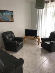 salon z 2 czarnymi krzesłami i telewizorem w obiekcie Casa Elias w mieście Nordeste