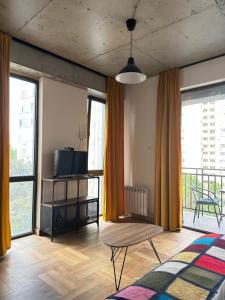 ein Wohnzimmer mit orangefarbenen Vorhängen und einem Tisch in der Unterkunft Gvazi Apartment in Tbilisi City