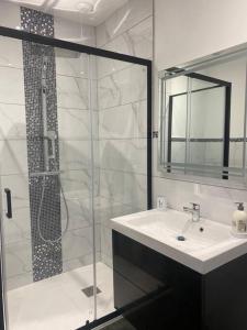 a bathroom with a glass shower and a sink at Le 202 de la gare: appartement neuf et climatisé in Chalons en Champagne