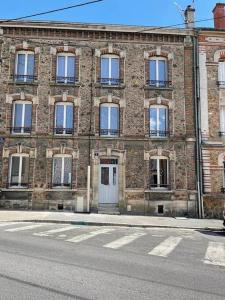 an old brick building with a door and windows at Le 202 de la gare: appartement neuf et climatisé in Chalons en Champagne