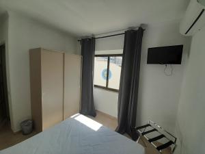 Schlafzimmer mit einem Bett und einem Fenster in der Unterkunft Flor de Sal in Vila Real de Santo António