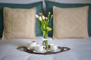 a tray with a vase of flowers and cups on a bed at Agriturismo San Francesco in Cortona