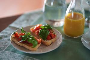 two sandwiches on a plate on a table with an orange juice at Agriturismo San Francesco in Cortona