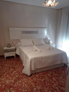 Un dormitorio con una gran cama blanca y una ventana en PATIO POZANCO, en Córdoba