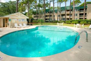 a large pool with chairs and a building in the background at Spa on Port Royal Sound 1321 in Hilton Head Island