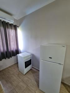 Il comprend une cuisine équipée d'un réfrigérateur et d'une cuisinière. dans l'établissement HOLIDAY HOME, à Durrës