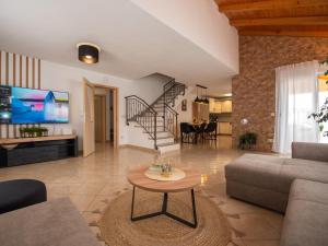 una sala de estar con un sofá y una mesa en Beautiful Holiday Home "Villa Luka", en Kaštel Štafilić