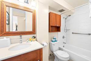 ein Badezimmer mit einem Waschbecken, einem WC und einem Spiegel in der Unterkunft Cozy Studio at the Pacific Monarch - Just steps from Beach in Honolulu