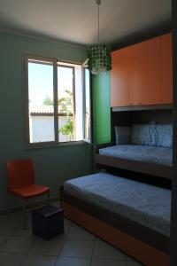 - une chambre avec un lit, une fenêtre et une chaise dans l'établissement Ville Tiffany, à Campofelice di Roccella