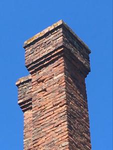 una chimenea de ladrillo en la parte superior de un edificio en Gilberts End Farm en Great Malvern