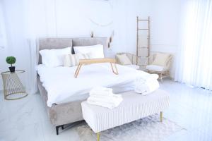 1 dormitorio blanco con 1 cama grande con almohadas blancas en סוויטות נוף שקיעה, en Peqi‘in H̱adasha