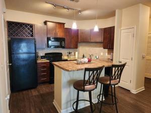 a kitchen with a counter and two bar stools at Adorable apartment w/ pool view in Charlotte