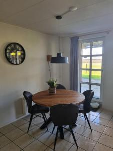 uma sala de jantar com uma mesa de madeira e cadeiras em Hemmer Hoeve em Hem