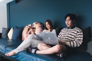 grupa ludzi siedzących na kanapie z laptopem w obiekcie Asa Hotel w mieście Chiang Mai