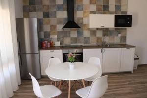 kuchnia z białym stołem i białymi krzesłami w obiekcie APARTAMENTOS RURALES ( LA COBIJÁ) APART Nº2 CONIL w mieście Conil de la Frontera