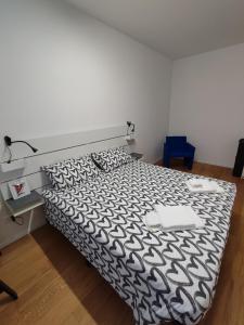 een slaapkamer met een bed met een zwart-wit dekbed bij La Casa di Priscilla in Fagagna