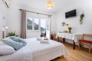 - une chambre avec un lit, une table et une fenêtre dans l'établissement Apartments Nikolic, à Gradac