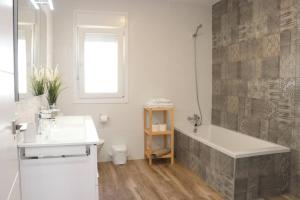 biała łazienka z wanną i umywalką w obiekcie APARTAMENTOS RURALES ( LA COBIJÁ) APART Nº2 CONIL w mieście Conil de la Frontera