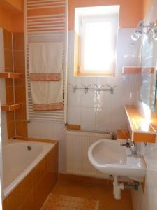 ein Bad mit einer Badewanne, einem Waschbecken und einem Fenster in der Unterkunft Privat Klonga in Smrečany