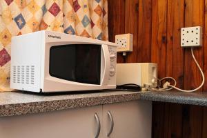a microwave oven sitting on top of a counter at Treehouse River Lodge in Elangeni