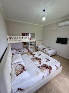 a bedroom with two beds and a tv at HOLIDAY HOME in Durrës