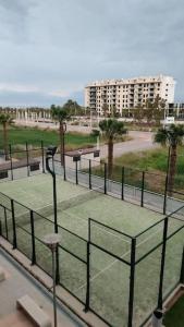 a tennis court with a net in a park at Lovely 1bed apartment with padel court near beach in Moncófar