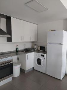 a kitchen with white cabinets and a washer and dryer at Lovely 1bed apartment with padel court near beach in Moncófar