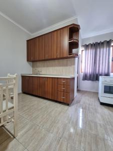 an empty kitchen with wooden cabinets and a stove at HOLIDAY HOME in Durrës