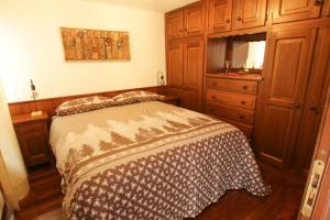 um pequeno quarto com uma cama e uma cómoda em Maison Baradis - grazioso e tranquillo trilocale con vista montagne em Allein