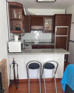 eine Küche mit zwei Barhockern an der Theke in der Unterkunft Casa Cris in Aracena