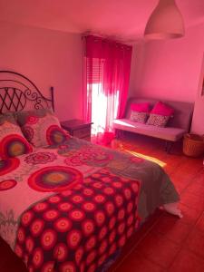 1 dormitorio con 1 cama grande con iluminación rosa en Casa Cris, en Aracena