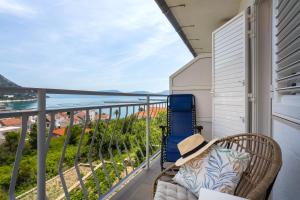 d'un balcon avec une chaise et une vue sur l'océan. dans l'établissement Apartments Nikolic, à Gradac