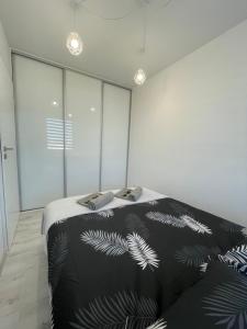 um quarto com uma cama com um cobertor preto e branco em N° 60 em Plock