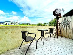 a patio with three chairs and a table and a windmill at vintagehouse1925Bali - Vacation STAY 14503 in Nagano