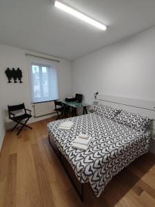 a bedroom with a bed with a black and white comforter at La Casa di Priscilla in Fagagna
