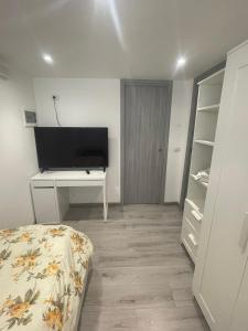 una camera con letto, scrivania e TV di Maison Rinaldi SrL a Bari