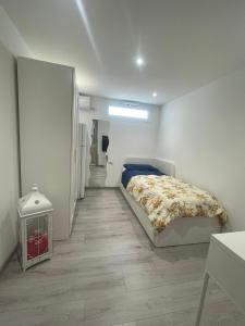 una camera bianca con un letto e un corridoio di Maison Rinaldi SrL a Bari