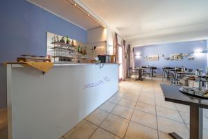 um restaurante com um balcão e uma mesa num quarto em Corte dei Melograni Hotel Resort em Otranto