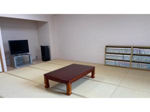 ein Wohnzimmer mit einem Couchtisch und einem TV in der Unterkunft Kohan no Onsen Yado Kunibiki - Vacation STAY 35288v in Izumo
