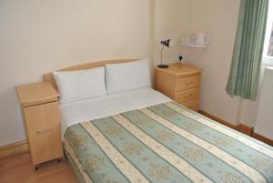 1 dormitorio con 1 cama, vestidor y 1 cama sidx sidx sidx sidx sidx sidx en The Belgrove Hotel, en Londres