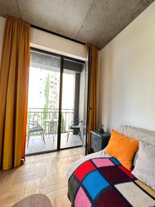 ein Schlafzimmer mit einem Bett und einem Balkon in der Unterkunft Gvazi Apartment in Tbilisi City