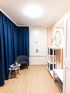 sala de estar con cortinas azules, silla y mesa en MADU-Living Vienna - Oskar, en Viena