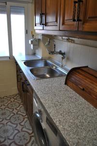 a kitchen with a sink and a washing machine at Viviendas De Uso Turistico Rocinante TOLEDO in Toledo